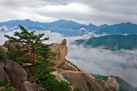 Hanging stone at the Ulsanbawi Rock against the fog seorak mountains at the Seoraksan National Park, South korea